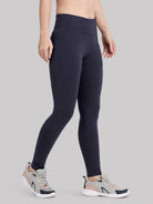 Person wearing navy leggings on a gray background